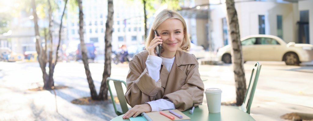 outgoing-young-happy-woman-sitting-cafe-outdoors-talking-mobile-phone-smiling-spending-time.jpg