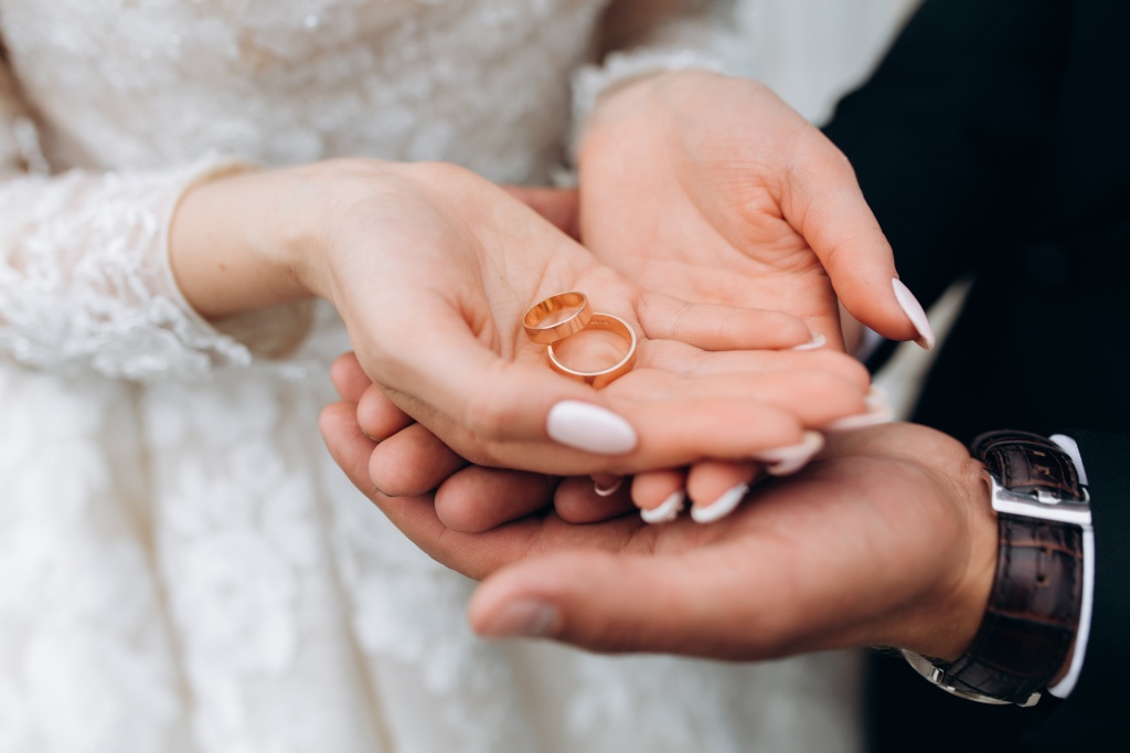 groom-holds-bride-s-hands-where-are-two-wedding-rings.jpg