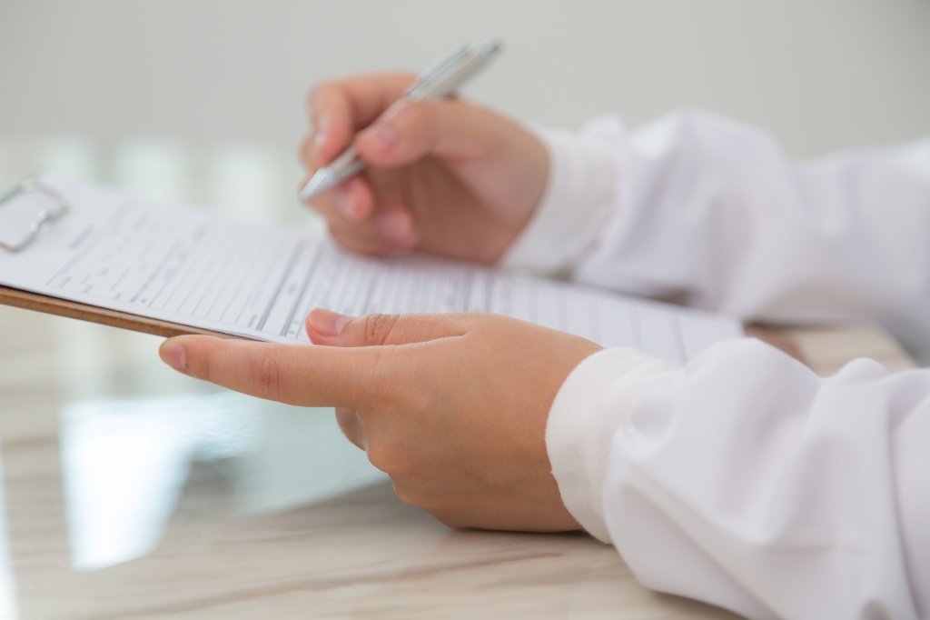 close-up-doctor-using-clipboard-pen.jpg