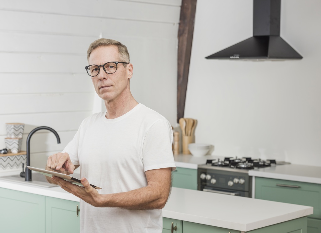 modern-senior-man-holding-his-tablet-kitchen.jpg